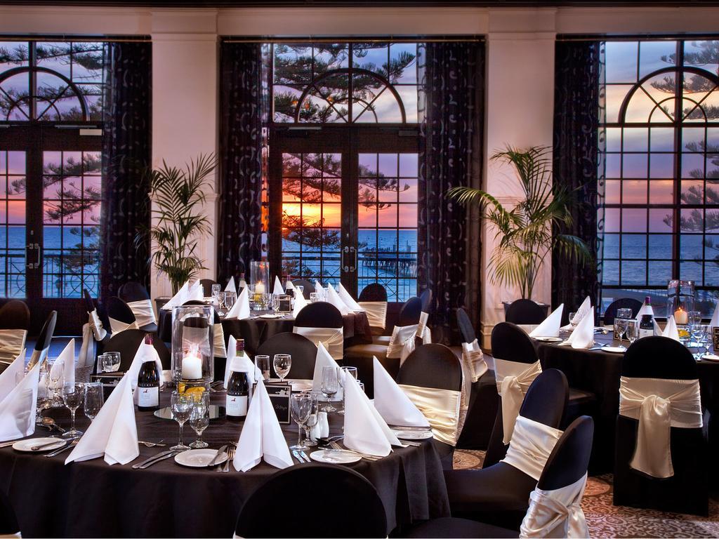 Stamford Grand Adelaide Otel Glenelg Dış mekan fotoğraf The photo shows an elegant dining setup inside a venue with large windows. The tables are adorned with black tablecloths and white napkins arranged in a stylish manner. Each table has glassware and other dining utensils placed neatly. In the backgrou